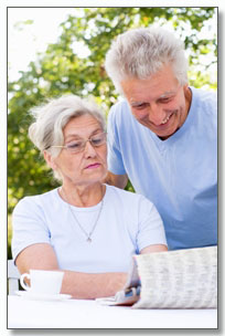 pareja de señores leyendo el periódico en un jardín