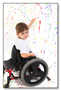 niño en silla de ruedas pintando con un rotulador sobre una pared