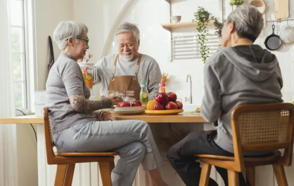 Foto con varias personas adultas sentadas en una cocina y charlando