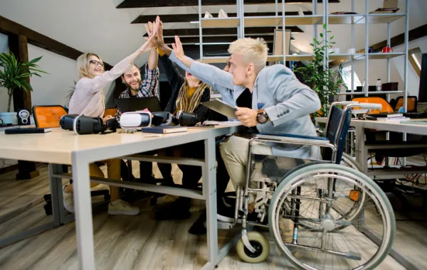 Foto de un equipo de trabajo con una persona en silla de ruedas