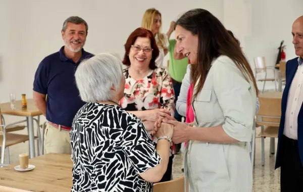 Foto de varias personas mayores hablando con la consejera de Inclusión Social, Juventud, Familias e Igualdad de Andalucía