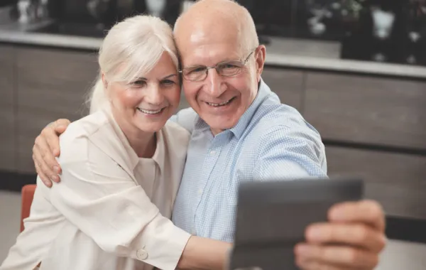 Foto de dos personas adultas haciendose una foto con un dispositivo movil