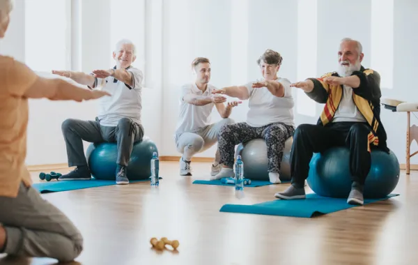 Foto de varias personas mayores haciendo ejercicio en una sala