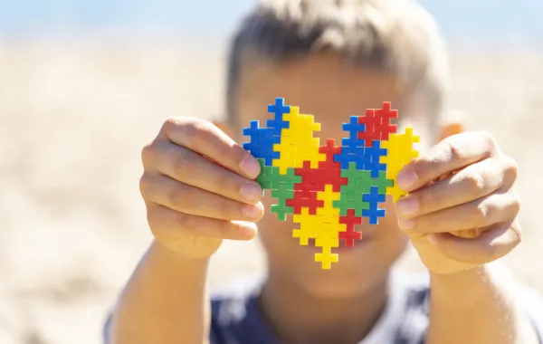 Foto de un niño que sostiene un puzzle con forma de corazón