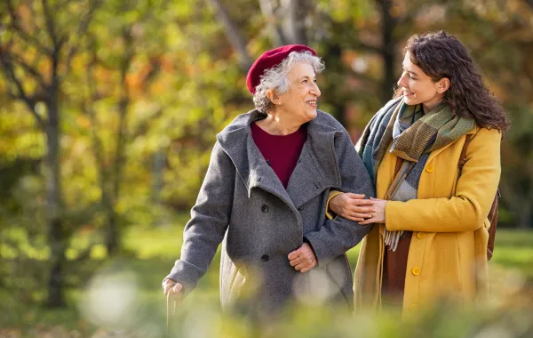 Foto de una mujer mayor y una mujer joven paseando por un parque