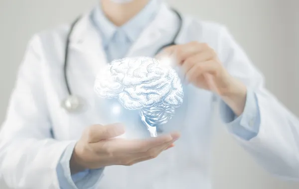Foto de un médico sosteniendo entre dos manos un dibujo virtual de un cerebro