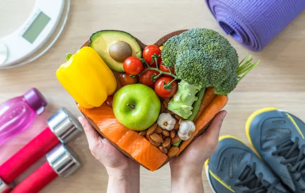 Foto de varias frutas y verduras y aparatos de ejercicio fisico