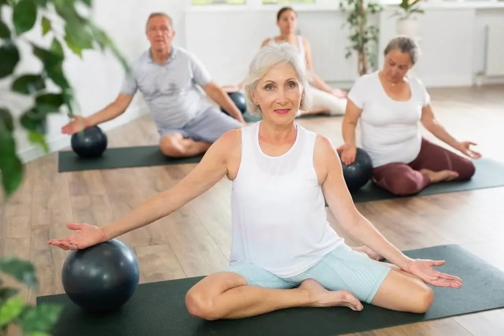 Personas mayores practicando pilates y disfrutando de sus beneficios trabajando conjuntamente cuerpo y mente