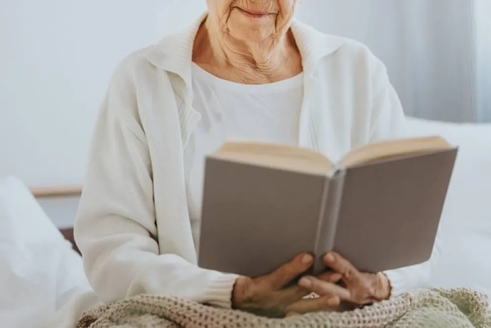 Lectura fácil. Mujer mayor leyendo un libro de tapas grises