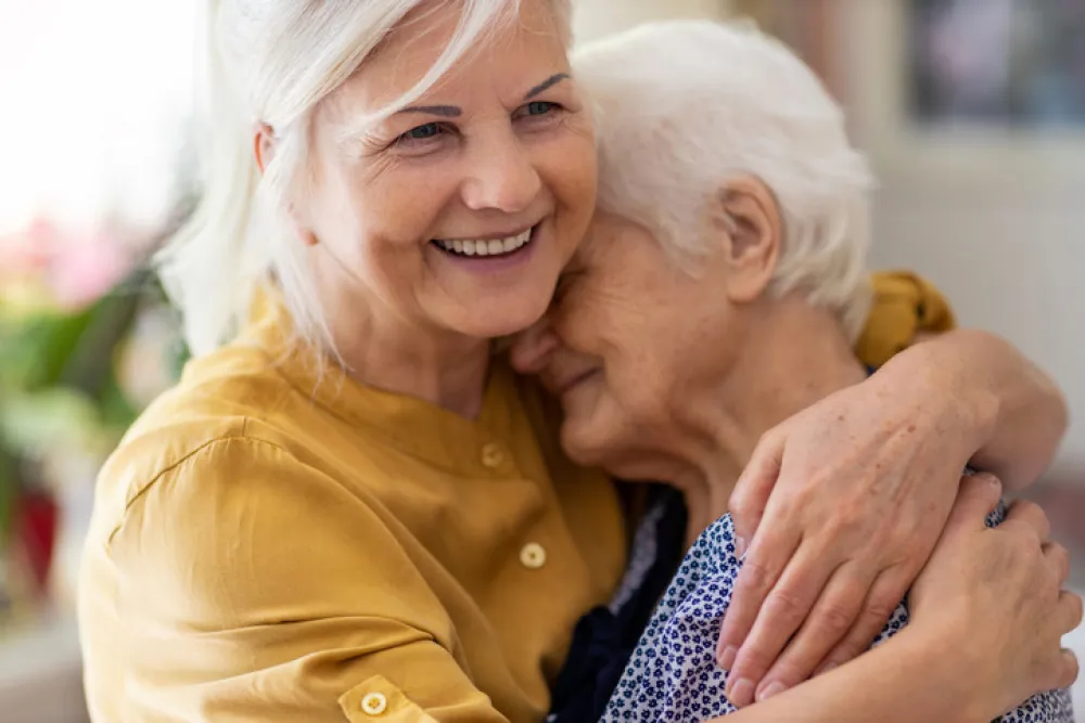 Foto de una mujer abrazando a una mujer mayor 