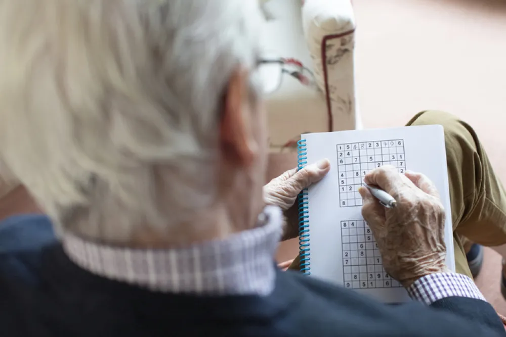 Foto de un señor mayor que está haciendo un sudoku