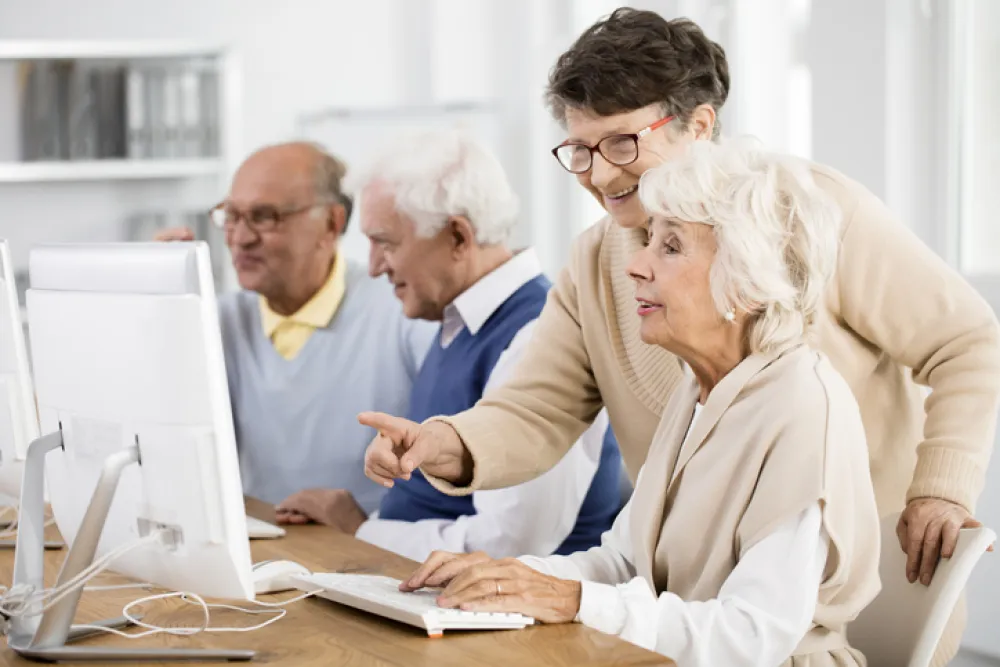 Foto de varias personas adultas sentadas en una clase con ordenadores