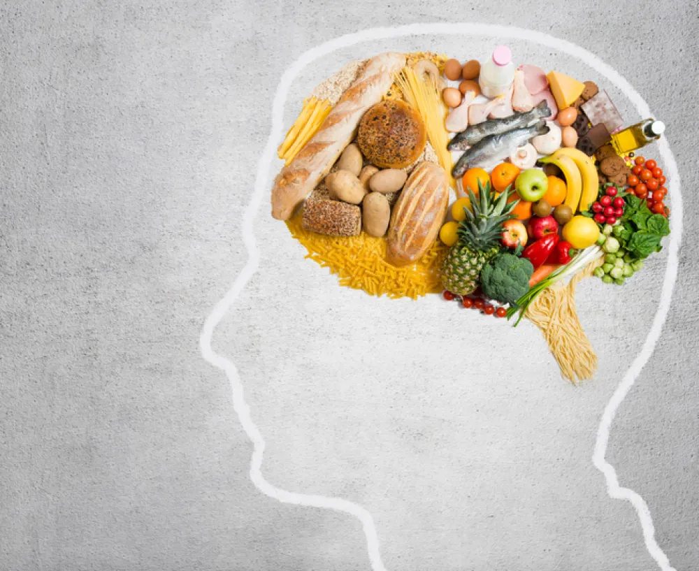 Foto de un dibujo de una cabeza de un persona y en el cerebro se ven frutas y verduras