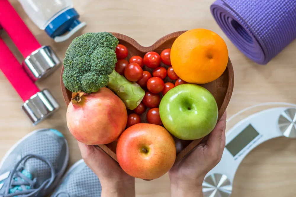 Foto de un surtido de frutas y verduras en una bandeja con forma de corazón