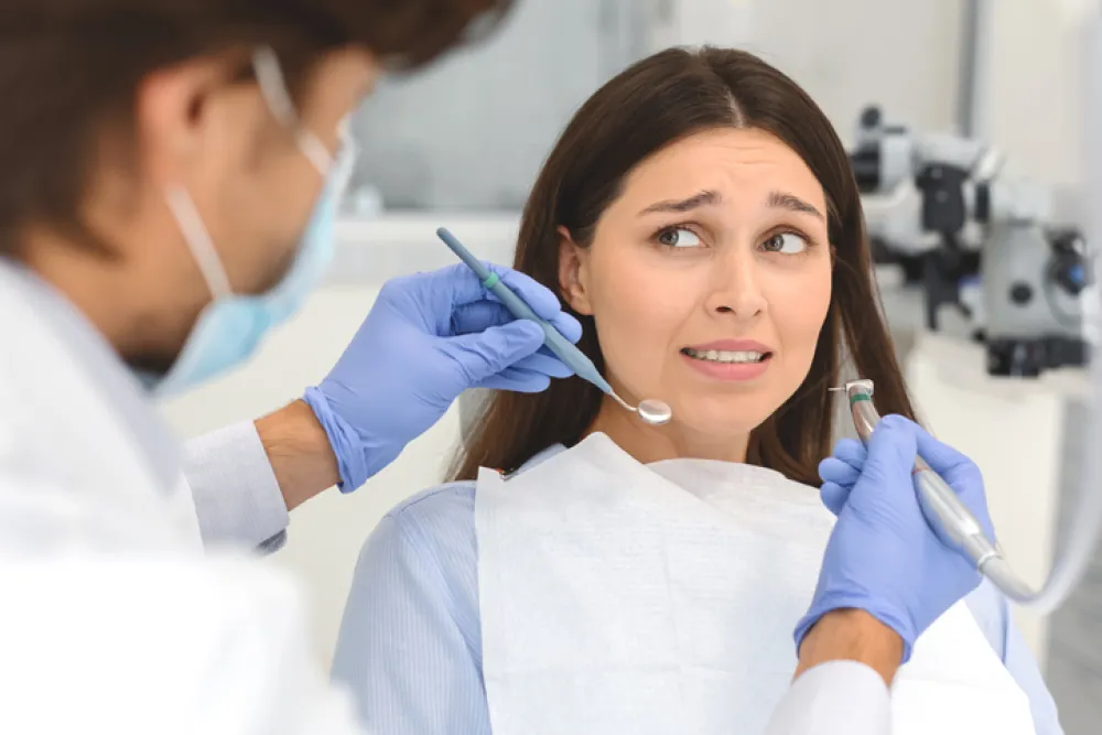 Foto de una persona con cara de miedo en el dentista
