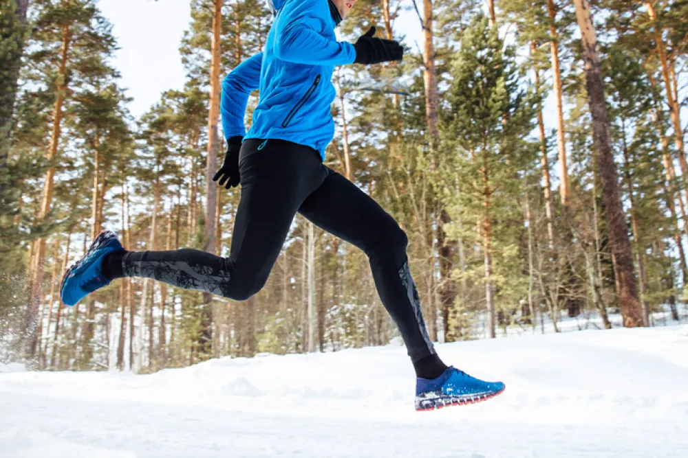 Foto de un deportista corriendo sobre la nieve