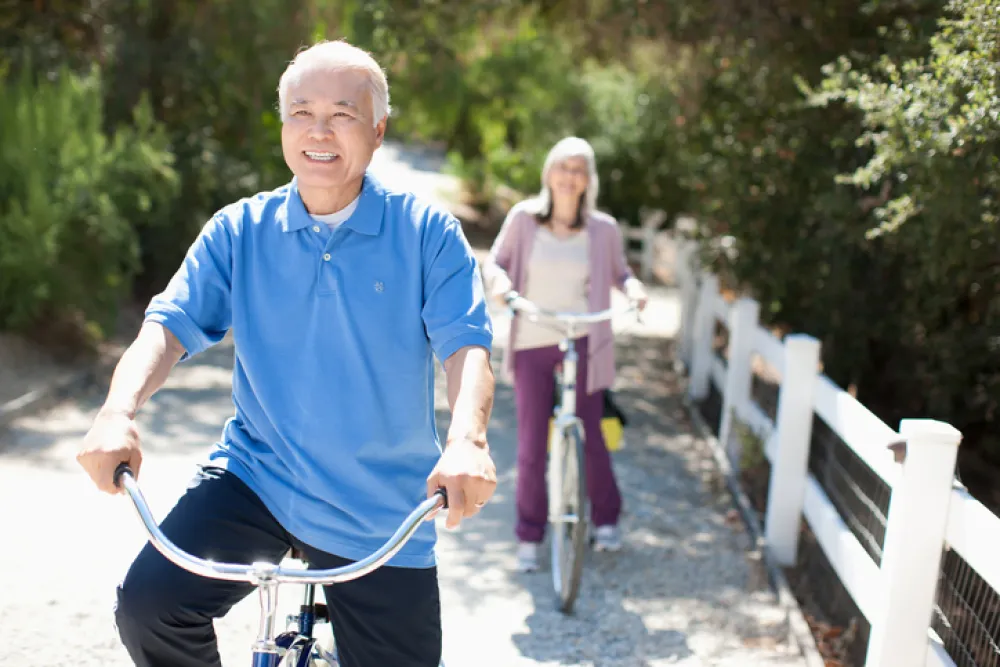 Foto de dos personas adultas montando en bici al aire libre