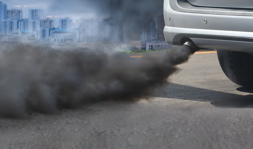 Foto de un coche echando mucho humo por el tubo de escape