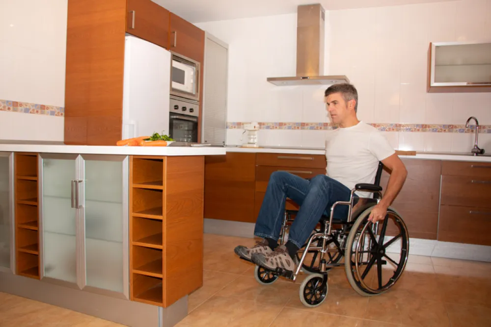Foto de un señor en silla de ruedas en una cocina