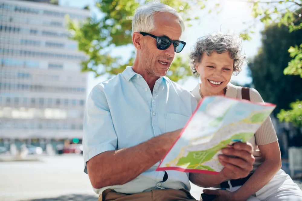 Foto de una pareja de adultos que miran un mapa turistico