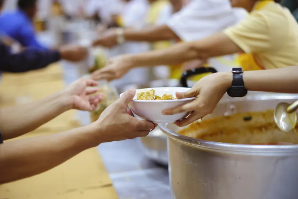 Fotos de personas dando de comer en un comedor social