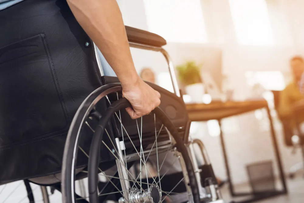 Foto de rueda de una silla de ruedas y una mano apoyada
