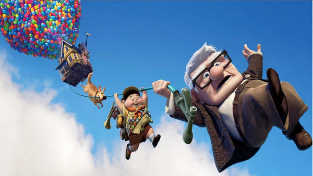 Foto película UP con el protagonista un anciano y un niño que se sujetan a una cuerda de globos que lleva la casa por los aires