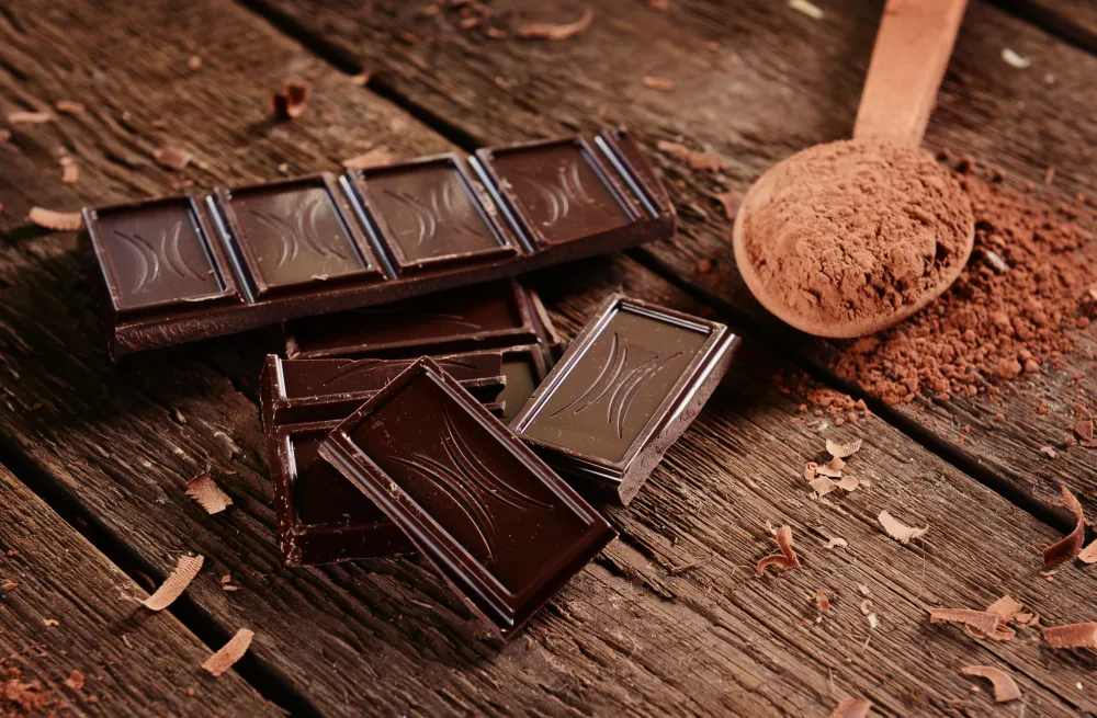 Foto de una onza de chocolate y chocolate en polvo encima de una mesa