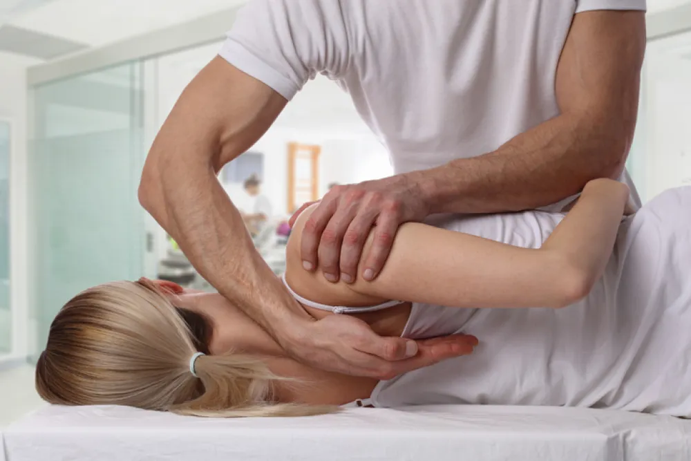 Foto de una mujer recibiendo un masaje de espalda por un fistioterapeuta