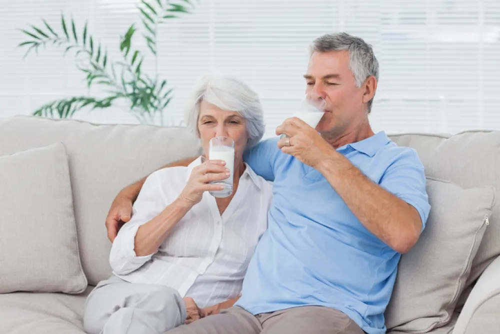 Foto de una pareja madura bebiendo vasos de leche