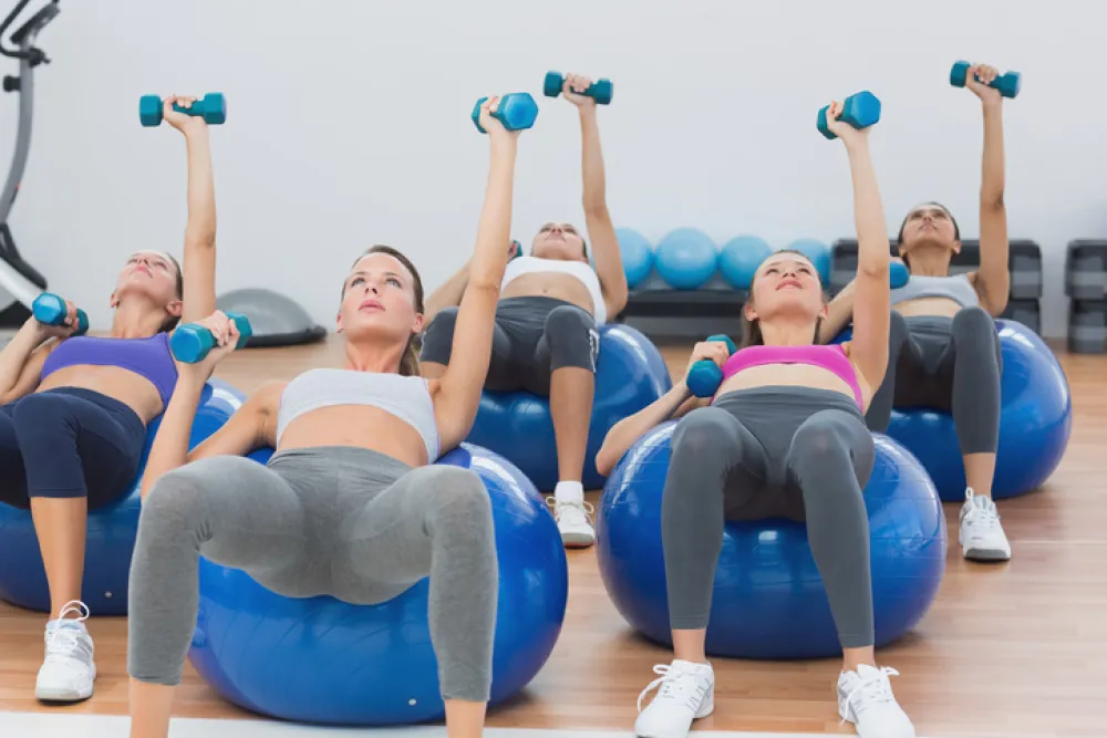 Foto de mujeres haciendo ejercicio encima de una pelota de salud