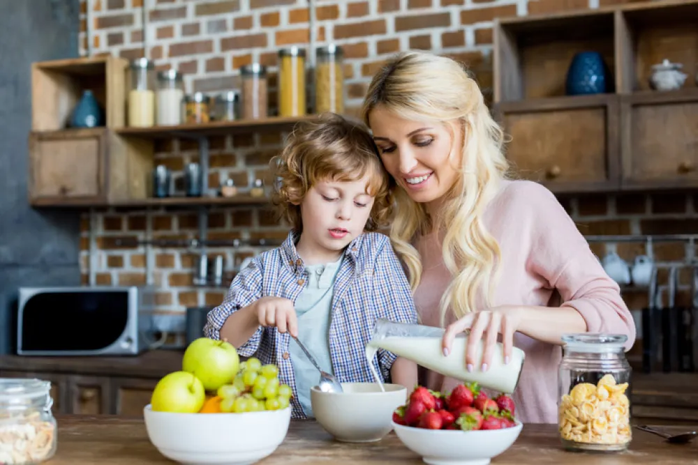 Foto de madre e hijo comiendo fruta y leche