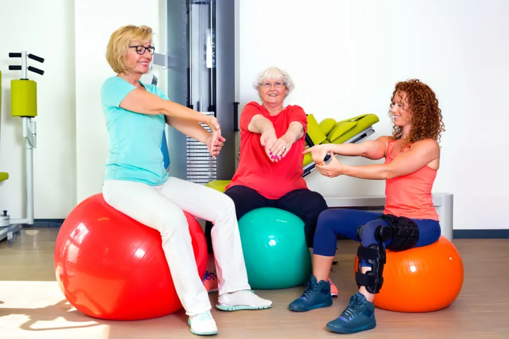 Foto de dos mujeres mayores haciendo ejercicio con una mujer joven