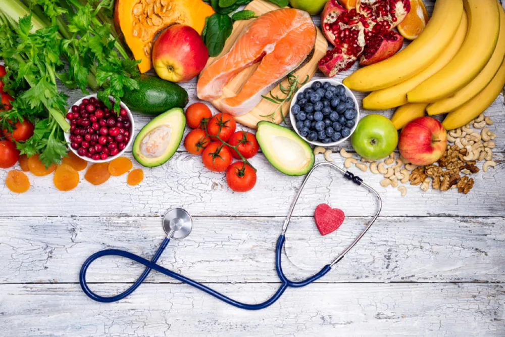 Foto de alimentos saludables con un fonendoscopio y un corazon