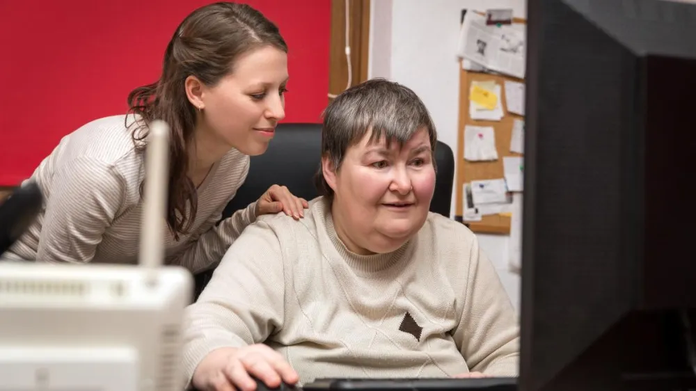 Foto de una mujer aprendiendo a utilizar un ordenador con una mujer joven