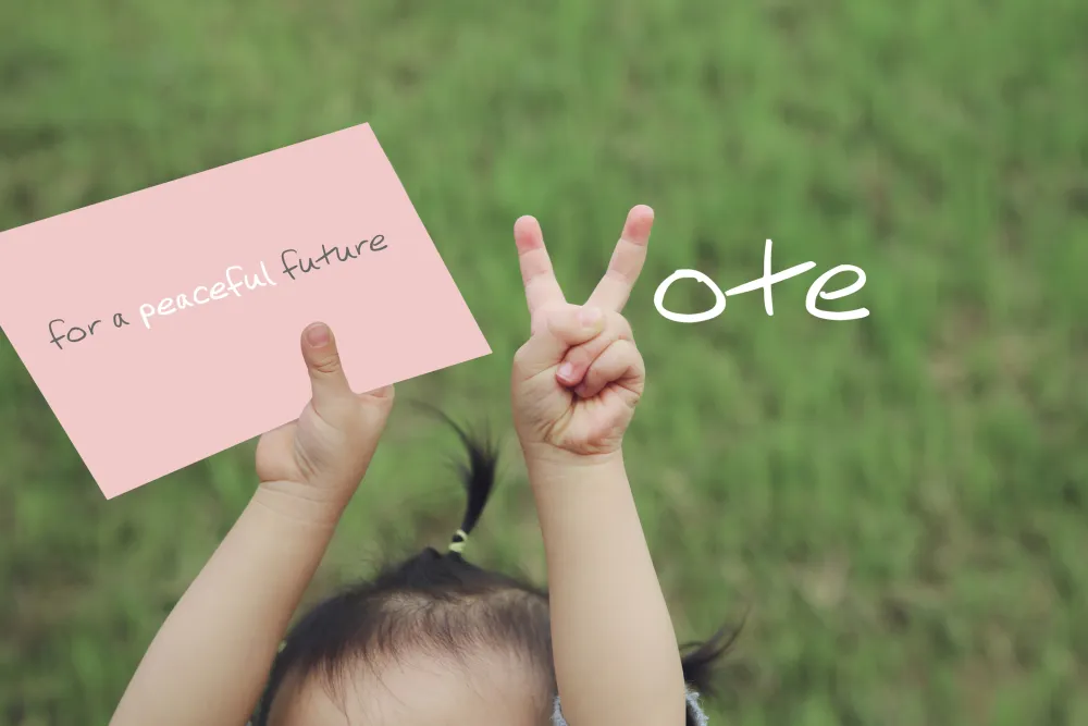 Foto de una mano de niño haciendo la señal de una V de votar