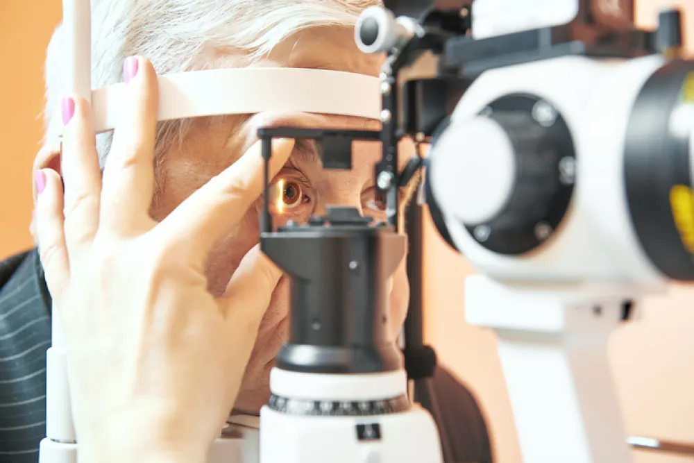 Foto de una mujer a la que le están revisando la vista con un aparato de óptica