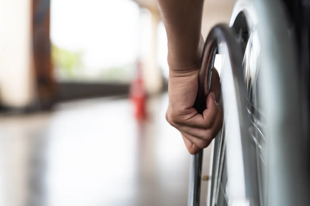 Foto de una mano que lleva una silla de ruedas