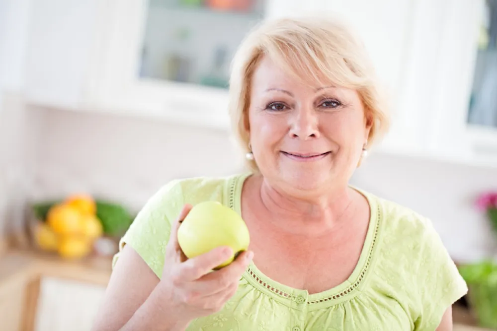 Foto de una señora comiendo una manzana